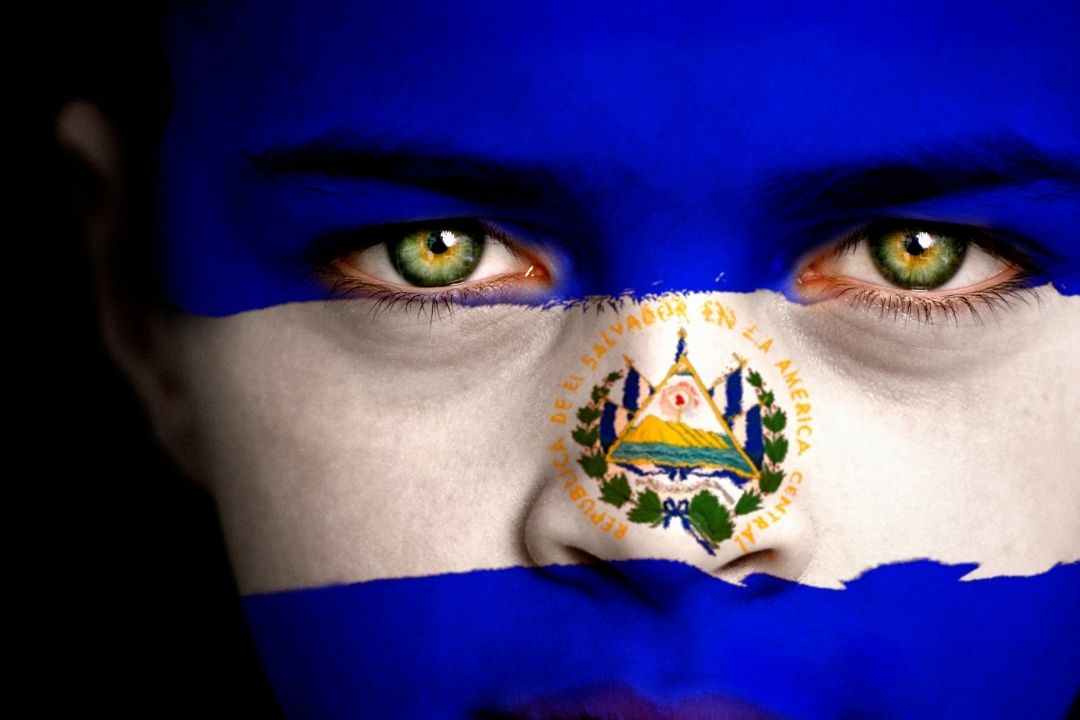 woman with her face painted like the el savador flag