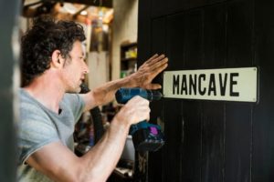 putting on a sign that reads mancave