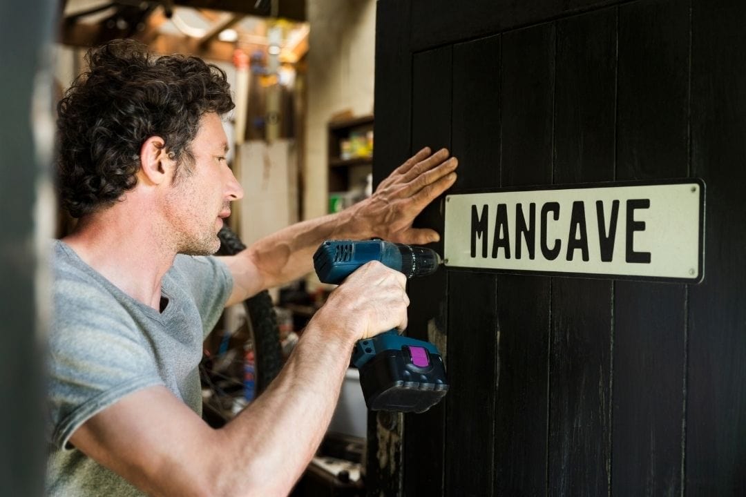 putting on a sign that reads mancave